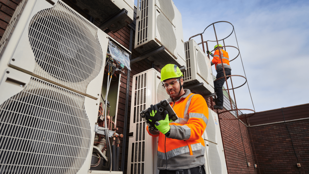Technicians installing aircon - building top